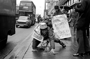 Raising Prints: One of the six student mountaineers making a horizontal attempt on Oxford Street today