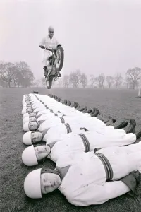 Danger Prints: Stunt team in action 1966 Man leaps on a motorcycle over men lying on the ground