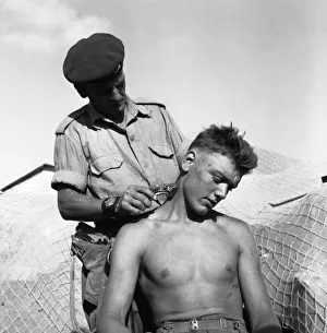 00173 Prints: Suez Crisis 1956 Brigade Sergeant Major Ernest Lambert cuts the hair of Gunner Jim