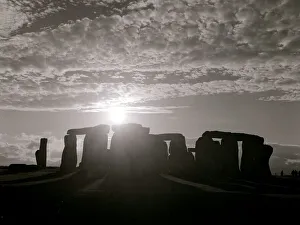History Prints: The sun as it rises above Stonehenge in Wiltshire south west England on the day of