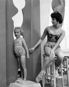 Stool Prints: Sunday; Picture; Beach Beauty prize contest: A tiny onlooker tries out the cut outs
