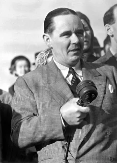 Sunday times golfing correspondant Henry Longhurst with microphone in hand at a meeting