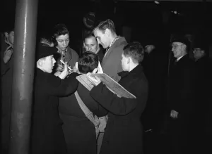 Sunderland footballer Don Revie signing autographs for young fans