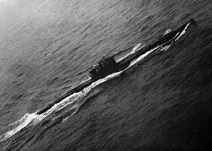 A surrendered German U-boat in the English channel heads to an Allied port under guard