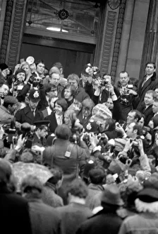 Surrounded by pressmen, police and fans, the bride and groom