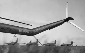 The tail of a Bristol Sycamore frames a flight of Meteors ready for take off at RAF