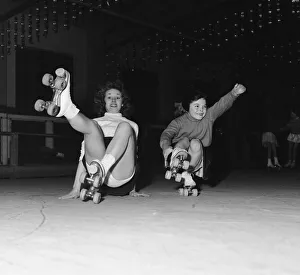 Accidents Prints: Teenager Betty Jones pictured roller skating with seven year old Anne Morgan at the rink