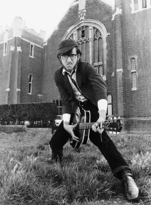 Teenagers Punk Rockers Julian Isaacs Aunty Pus in a punk rock uniform playing guitar