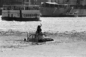 00967 Prints: Television presenter Peter Duncan in a VW Beetle car in the River Thames