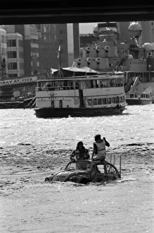 00967 Prints: Television presenter Peter Duncan in a VW Beetle car in the River Thames