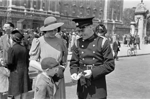 Temporary fireman Skillern receives George medal at the Palace, with his wife and child