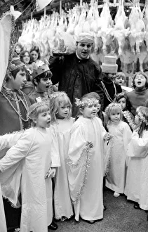 Terry Champion of Hornsey, London, joins the children in carol singing during his work