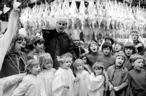 Terry Champion of Hornsey, London, joins the children in carol singing during his work