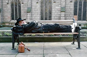 Literature Prints: Terry Pratchett lying down on a bench. Pratchett is an English author of fantasy novels
