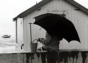 Shelter Prints: Thorpe Bay in Essex - April 1970 Holidaymaker on the beach with an umbrella