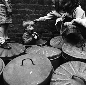 Three-year-old Robert Watson plays in the dustbin outside Number Two Court