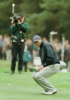 Crouching Prints: Tiger Woods watches a putt just miss the hole October 1998 during the 1998 World