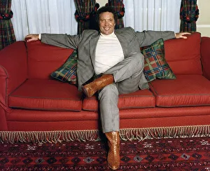 Tom Jones entertainer singer sits on sofa setee
