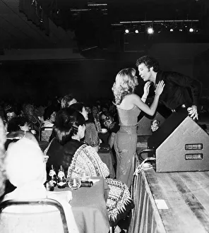 Tom Jones Singer on stage being approached by a Yopung Woman who wants a Kiss Circa