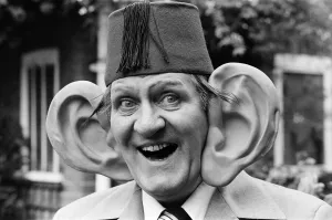 Giant Prints: Tommy Cooper, 15th July 1977. Pictured wearing a giant pair of ears