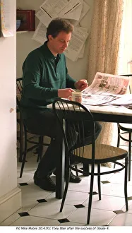 Tony Blair leader of the Labour Party at home in kitchen reading the newspapers after his