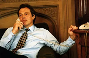 Tony Blair sitting on the sofa holding a telephone handset to his ear