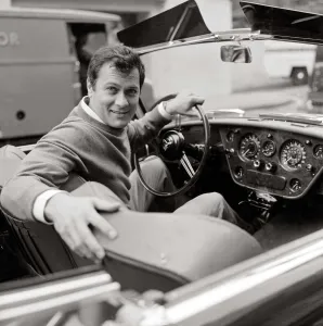 Tony Curtis, american actor poses for pictures in his Alvis TE21 motorcar in
