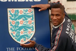 Badge Prints: Tottenham and England footballer Les Ferdinand with his hands round a large England badge