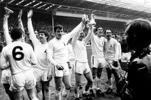 Tottenham Hotspur players celebrate with the FA Cup trophy on the pitch at Wembley after