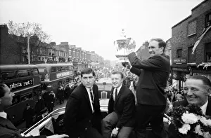 Tottenham Hotspur team hold the FA Cup trophy aloft from an open top double decker bus to