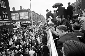 Tottenham Hotspur team hold the FA Cup trophy aloft from an open top double decker bus to