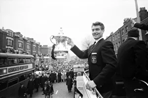 Tottenham Hotspur team hold the FA Cup trophy aloft from an open top double decker bus to