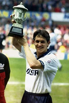 Tottenham Hotspurs striker Gary Lineker holds aloft a trophy presented by Bryan Robson