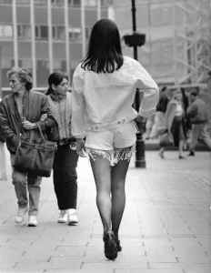 00038 Prints: Tracy strutting her stuff on busy steet wearing white denim jacket