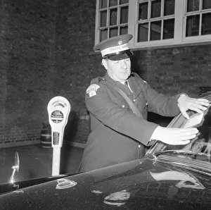 00016 Prints: Traffic warden during training sticking fine on window screen parking clock