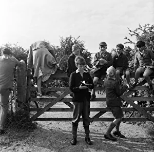 Trainspotters sitting on a gate on the edge of Cambridge watching the London express