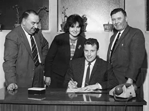 Transfer complete... Mrs. Burrows watches her husband Harry sign the form to complete