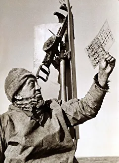 A trawler man on deck, studying an aircraft chart May 1942
