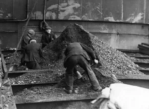 00054 Prints: Trimmers on board the Camberwell levelling a hatch off at the Tyne Improvement