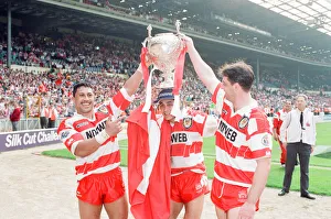 A trio of Wigan players celebrate their 20 - 14 victory over Widnes in the Rugby League