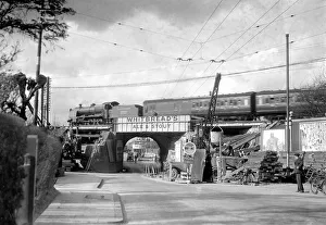 Trolley bus wires frame this Southern Railway passenger train speeding over Malden