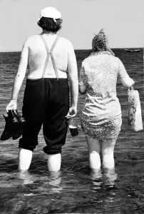 00055 Prints: Typical Geordie couple Bill and Effie walk in the sea - Bill has his bottle of Brown Ale
