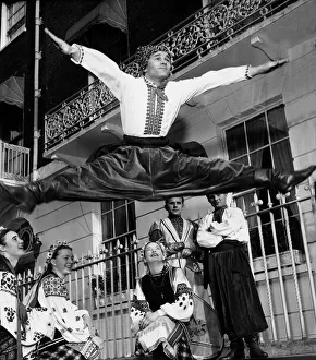 00046 Prints: Ukranian dancer Dmytro Paraduik legs open wide as he leap over three girls as they