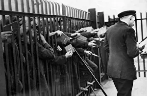 Unemployment Prints: Unemployed sailors thrusting their discharge books through a landing-stage barrier