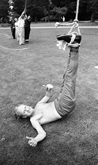 Upside Down Straight Jacket Escape, man tied up hanging upside down by a rope