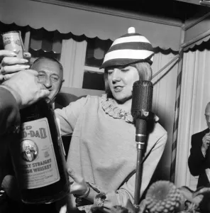 V. C. G. B. Luncheon: Cilla Black holding large whiskey bottle
