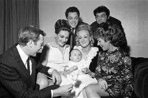 01053 Prints: Val Doonican and his wife Lynn in supporting roles at the christening of baby Russell