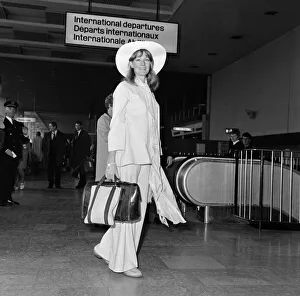 Vanessa Redgrave, wearing a beige bell-bottomed cotton trouser suit with a floppy hat to