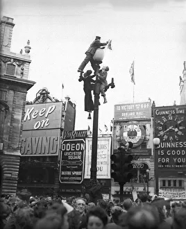 VE Day celebrations in London at end of WW2 people on a lamp post