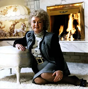 Jg Scan Prints: Vera Weisfeld sitting on white fire side rug leaning on foot stool grey